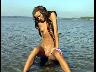 Tanned, bare teenage squirting in the sea